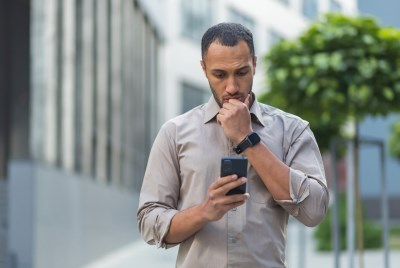 Man gazing down at his cell phone